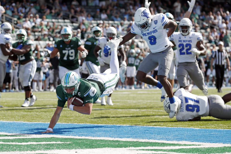 Tulane quarterback Michael Pratt (7) dives in the end zone past Memphis linebacker Xavier Cullens (8) to score a touchdown during the first half of an NCAA college football in New Orleans, Saturday, Oct. 22, 2022. (AP Photo/Tyler Kaufman)