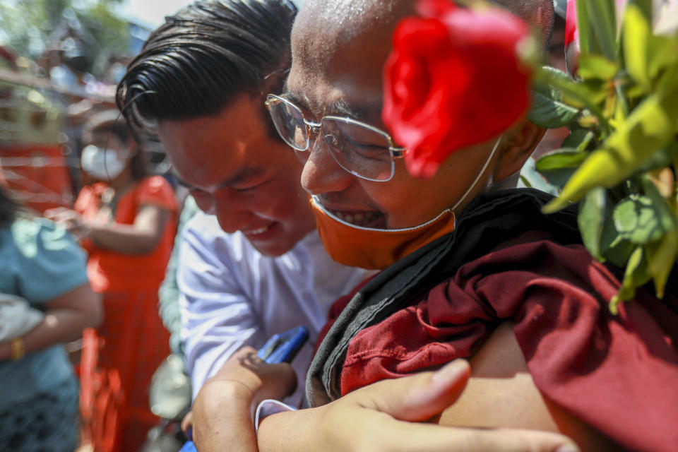 A released prisoner hugs a Buddhist monk outside the Insein prison in Yangon, Myanmar Friday, Feb. 12, 2021. Myanmar's coup leader used the country's Union Day holiday on Friday to call on people to work with the military if they want democracy, a request likely to be met with derision by protesters who are pushing for the release from detention of their country's elected leaders. The new junta announced it would mark Union Day by releasing thousands of prisoners and reducing other inmates’ sentences. (AP Photo)