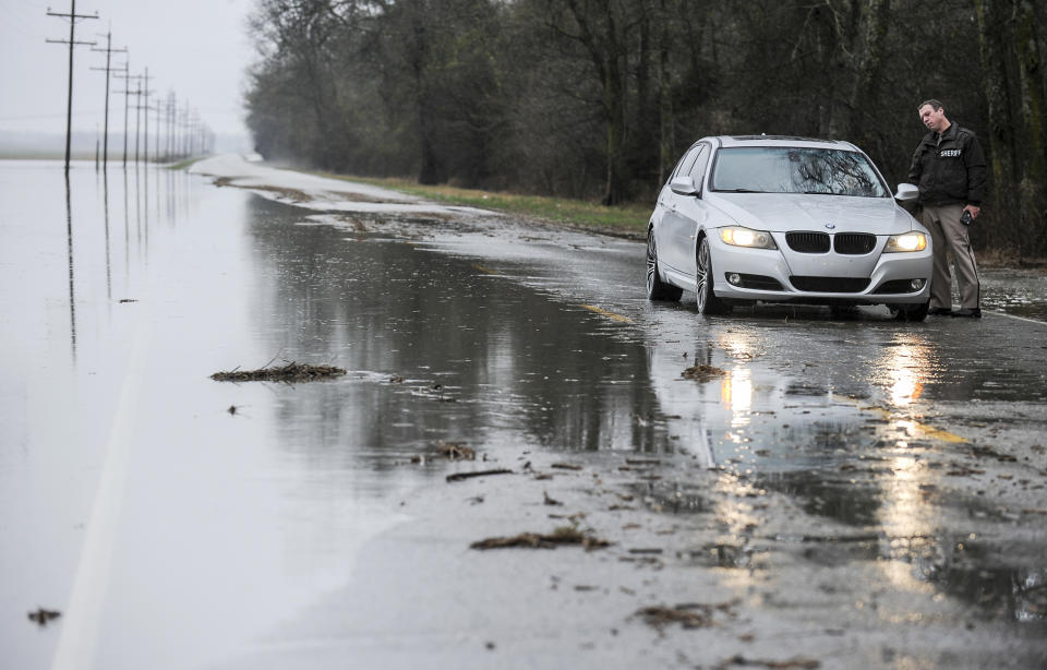 Limestone County Sheriff Office's information officer Stephen Young talks to a driver on a section of Mooresville Road, between Humphrey Road and Old Hwy 20 that was partially flooded and closed to traffic on Friday, Feb. 22, 2019, in Decatur, Ala. (Jeronimo Nisa/The Decatur Daily via AP)