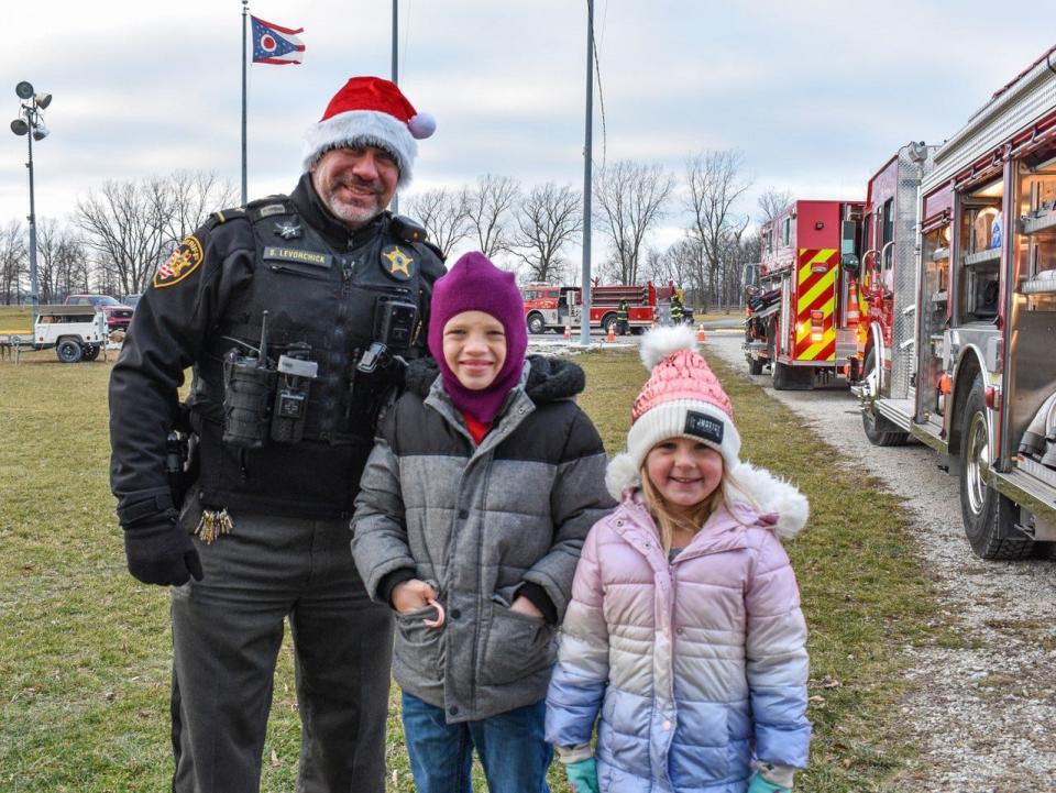 In a proactive effort to protect local children, Ottawa County Sheriff Stephen Levorchick is offering child identification cards to area families. Here, he stands with eight-year-old Carson and five-year-old Lily Hotz of Port Clinton.