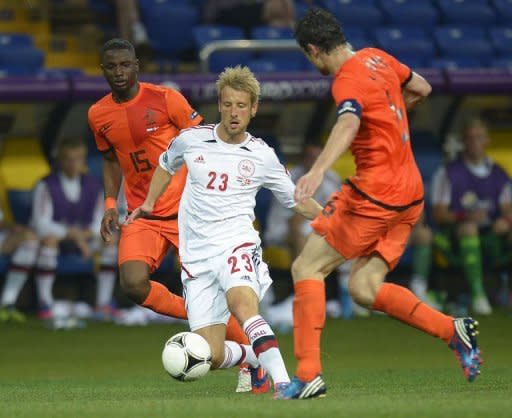 Danish forward Tobias Mikkelsen (C) vies with Dutch midfielder and captain Mark van Bommel (R) and Dutch defender Jetro Willems during their Euro 2012 football group match