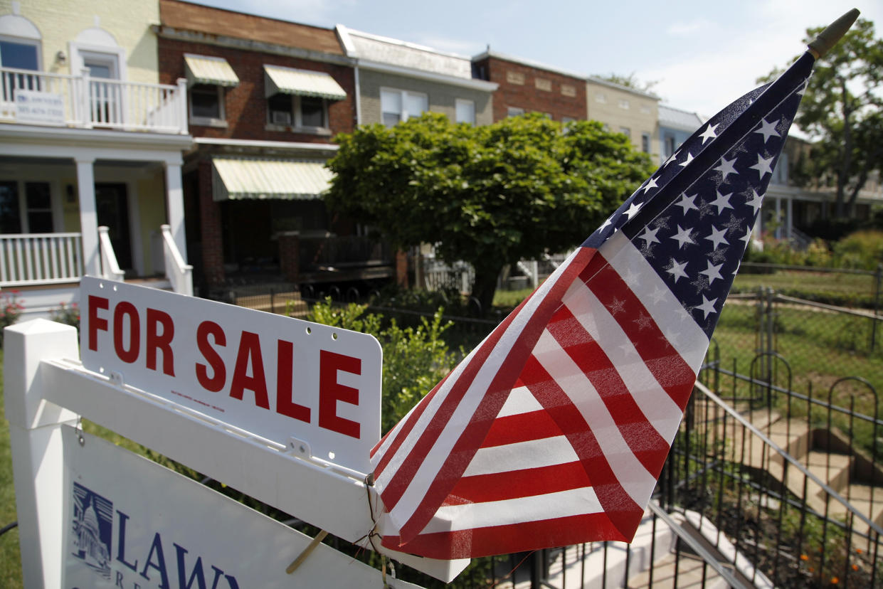 A U.S. flag decorates a for-sale sign at a home in the Capitol Hill neighborhood of Washington, August 21, 2012. President Barack Obama said on Monday the U.S. housing market was 