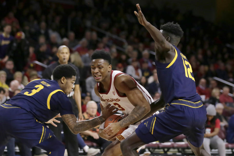 Southern California guard Elijah Weaver, center, drives to the basket between California guard Paris Austin, left, and forward Kuany Kuany, right, during the second half of an NCAA college basketball game in Los Angeles, Thursday, Jan. 16, 2020. (AP Photo/Alex Gallardo)