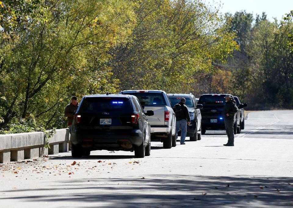 Officials are pictured Monday, Oct. 17, 2022, at the bridge where bodies were found in Okmulgee.