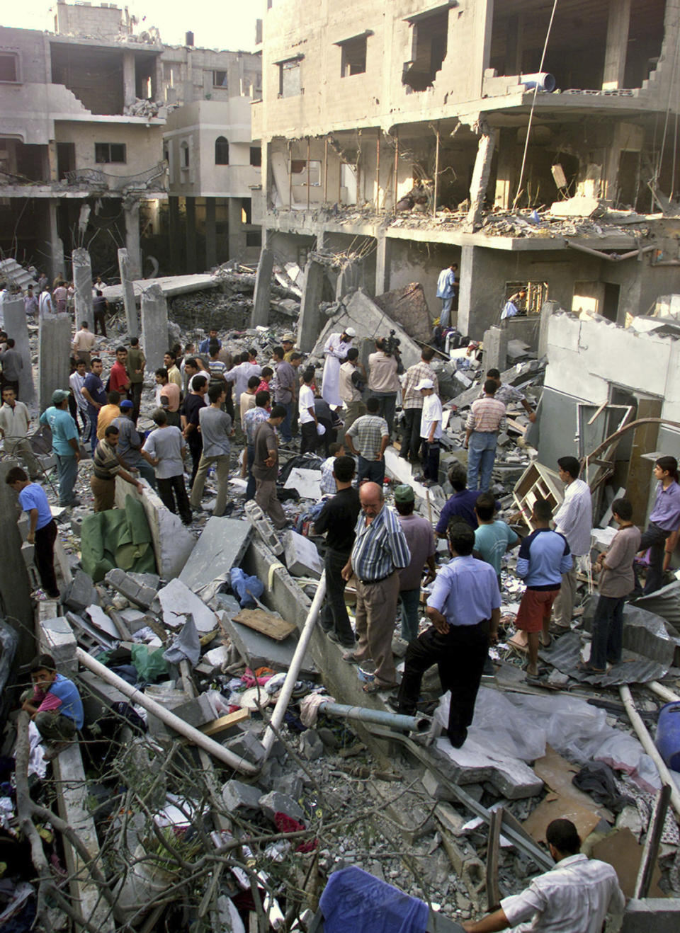 FILE - Workers sift through the rubble of a destroyed house where Hamas military wing commander Salah Shehadeh, who was killed, in Gaza City, on July 23, 2002 file photo. Prime Minister Benjamin Netanyahu and other Israeli leaders have repeatedly threatened to kill Hamas leaders following the group's deadly Oct. 7, 2023 cross-border attack that sparked the war in Gaza. Israel has a long history of assassinating its enemies, many carried out with precision airstrikes. (AP Photo/Adel Hana, File)