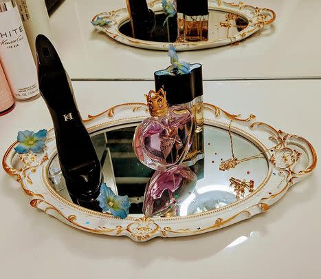 A gold decorative mirror you can hang or even use as a tray