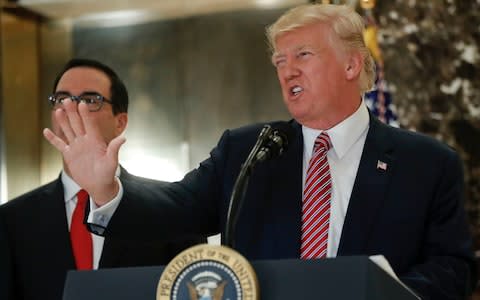 President Donald Trump, accompanied by Steven Mnuchin, reacts to questions from members of the media in the lobby of Trump Tower in New York, Tuesday, Aug. 15, 2017 - Credit: AP