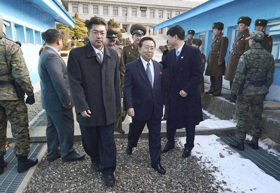Head of the North Korean high-level delegation, Won Tong Yon (C) crosses the concrete border which separates the two Koreas at the truce village of Panmunjom in the demilitarised zone, north of Seoul February 12, 2014. North and South Korea held their first high-level talks in seven years on their armed border on Wednesday, exploring ways to improve ties while the South and the United States geared up for large-scale military drills that have angered Pyongyang. (REUTERS/Unification Ministry/Yonhap)