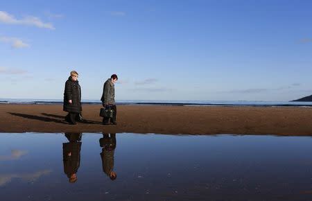 Patricia Gearon (L), 64, and her sister Helen McKinley, 65, walk to the site where their brother Peter Wilson's remains were discovered in 2010 at Waterfoot beach in County Antrim November 5, 2014. REUTERS/Cathal McNaughton