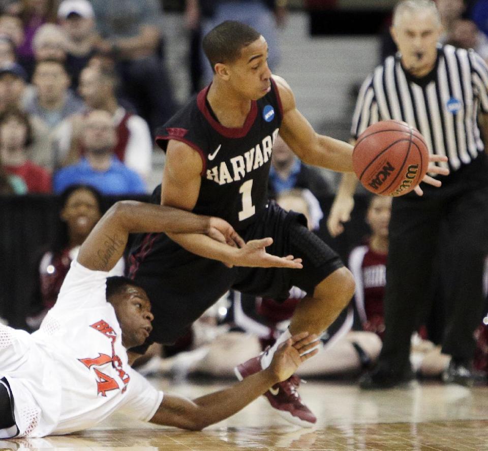 Harvard’s Siyani Chambers (1) and Cincinnati’s Ge'Lawn Guyn (14) fight for a loose ball in the second half during the second-round of the NCAA college basketball tournament in Spokane, Wash., Thursday, March 20, 2014. (AP Photo/Young Kwak)