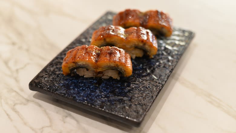 unagi sushi on black clay plate