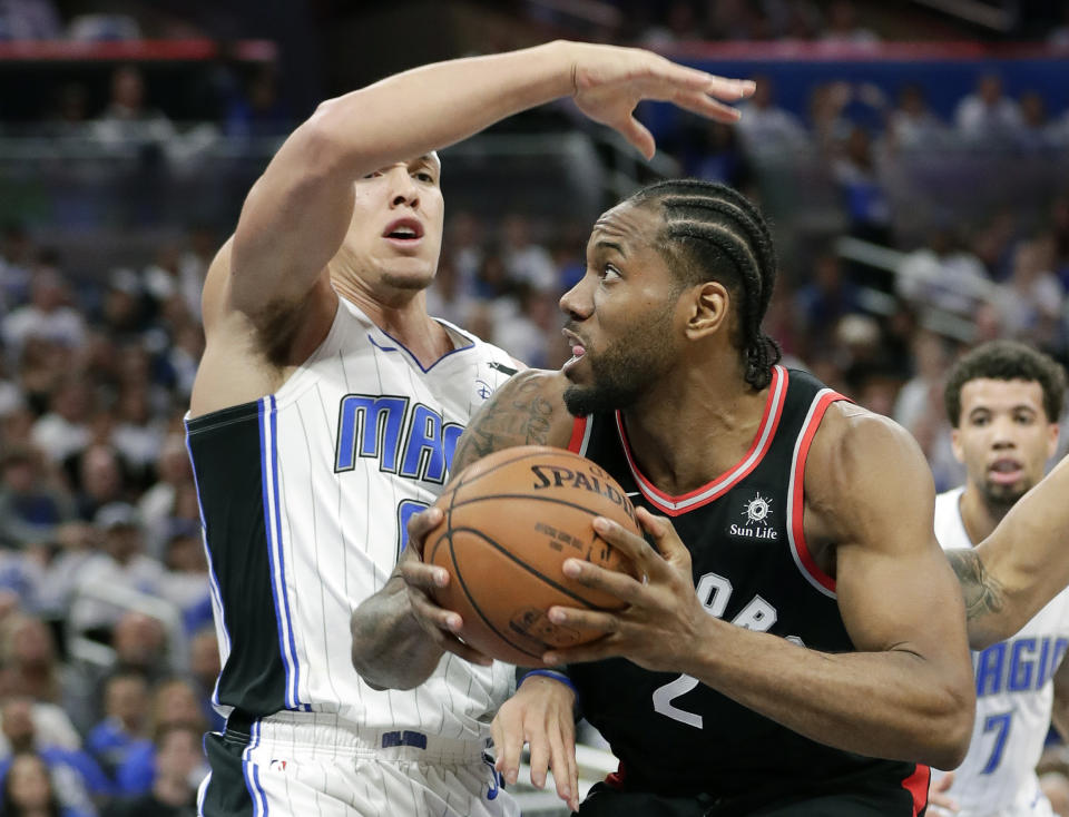 Toronto Raptors' Kawhi Leonard, right, looks looks for a shot as he is defended by Orlando Magic's Aaron Gordon during the first half in Game 3 of a first-round NBA basketball playoff series, Friday, April 19, 2019, in Orlando, Fla. (AP Photo/John Raoux)
