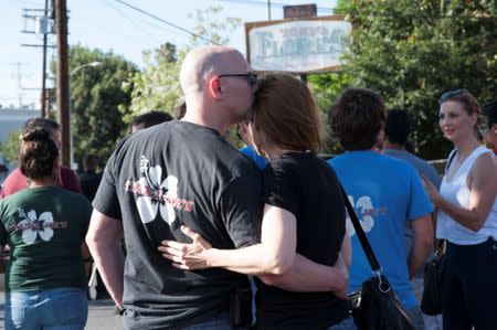 A Trader Joe's employee embraces a woman in a parking lot near a Trader Joe's store where a hostage situation unfolded in Los Angeles, California, July 21, 2018. REUTERS/Andrew Cullen