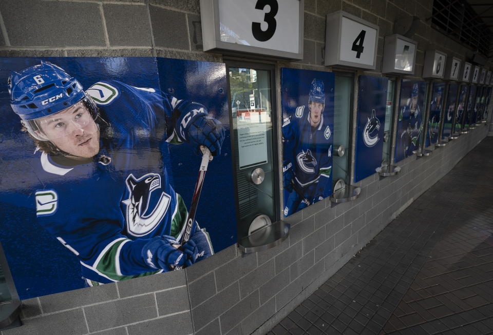 Photos of Vancouver Canucks players are pictured outside the closed box office of Rogers Arena in downtown Vancouver, British Columbia, Thursday, April 8, 2021. The Canucks said Wednesday that 21 players, including three from the taxi squad, and four members of the coaching staff have tested positive in a COVID-19 outbreak. The NHL is in the most difficult position among the four major North American professional sports leagues on vaccinations because seven of its teams are based in Canada. (Jonathan Hayward/The Canadian Press via AP)