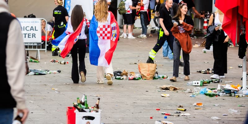 EM, Spanien - Kroatien, Vorrunde, Gruppe B, 1. Spieltag. Kroatische Fans gehen über den mit Müll bedeckten Breitscheidplatz an der Kaiser-Wilhelm-Gedächtniskirche.<span class="copyright">Christoph Soeder/dpa</span>