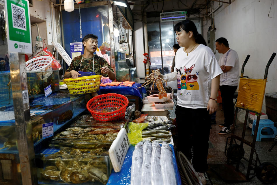 Vendedores en un mercado de pescado y marisco en Beijing, China August 24, 2023. REUTERS/Florence Lo