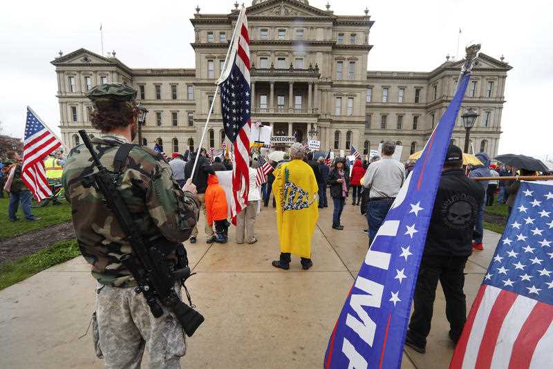 A protester carries his rifle at the State Capitol in Lansing, Michigan.