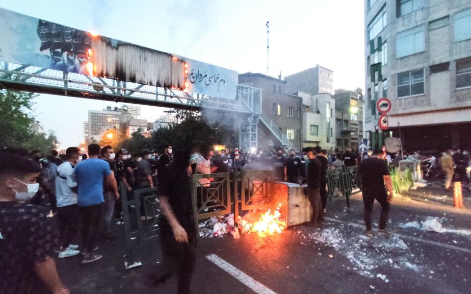 Iranian demonstrators burning a rubbish bin in the capital Tehran - AFP