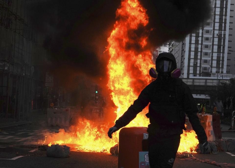 Protestors set fire on a street to prevent police from approaching in Hong Kong, Sunday, Oct. 20, 2019. Hong Kong protesters again flooded streets on Sunday, ignoring a police ban on the rally and setting up barricades amid tear gas and firebombs. (AP Photo/Vincent Yu)