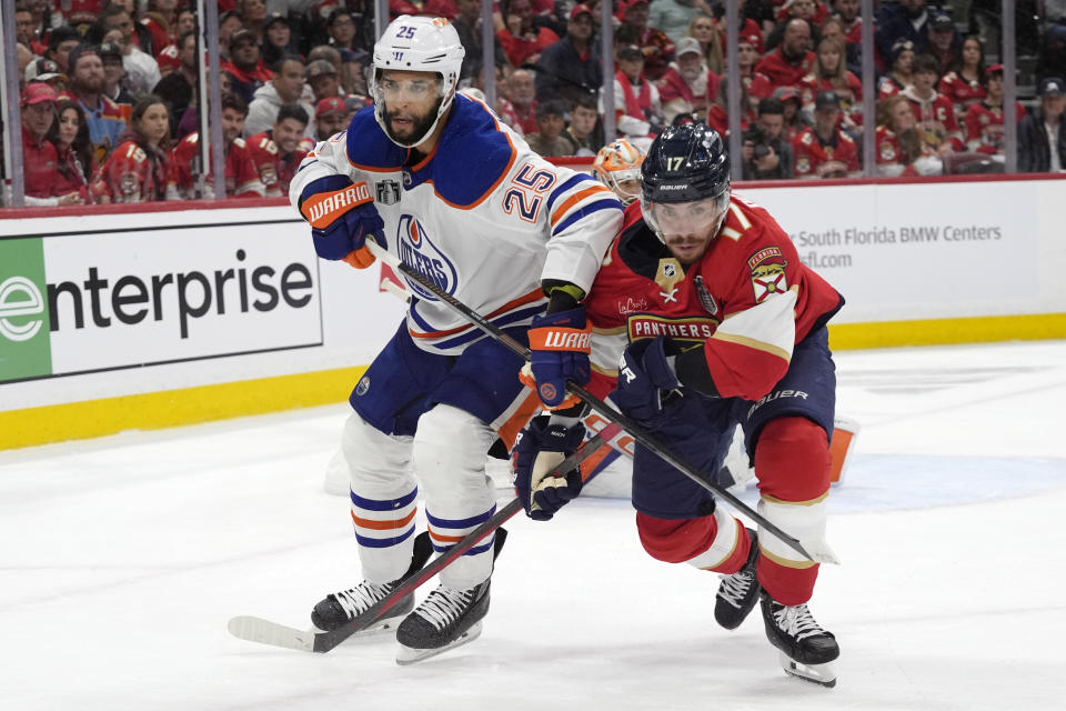 Edmonton Oilers defenseman Darnell Nurse (25) and Florida Panthers center Evan Rodrigues (17) fight for position during the second period of Game 1 of the NHL hockey Stanley Cup Finals, Saturday, June 8, 2024, in Sunrise, Fla. (AP Photo/Wilfredo Lee)