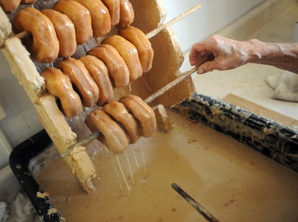 Jackie Wade of the Mill Gap Ruritans dips donuts into a mixture of confectioners sugar, water and maple flavoring in Monterey during the Maple Festival in Highland County.