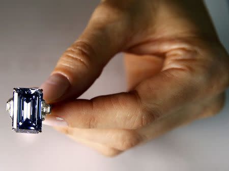 A Christie's employee poses with the 14.62 carats Oppenheimer Blue diamond during a preview in Geneva, Switzerland May 12, 2016. REUTERS/Denis Balibouse