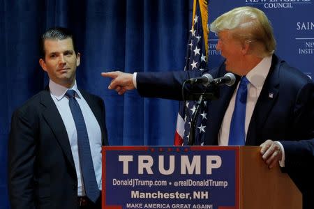 FILE PHOTO: Then U.S. Republican presidential candidate Donald Trump (R) welcomes his son Donald Trump Jr. to the stage at one of the New England Council's "Politics and Eggs' breakfasts in Manchester, New Hampshire November 11, 2015. REUTERS/Brian Snyder/File Photo