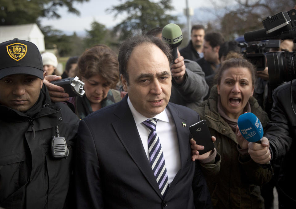 Monzer Akbik, center, a spokesman of the Syrian National Coalition, Syria's main political opposition group, is surrounded by journalists after a meeting with the Syrian government at the United Nations headquarters in Geneva, Switzerland, Sunday, Jan. 26, 2014. Syrians on opposite sides of their country’s civil war tried again Sunday to find common ground, with peace talks focusing on an aid convoy to a besieged city that once more came under mortar attack from the government. (AP Photo/Anja Niedringhaus)