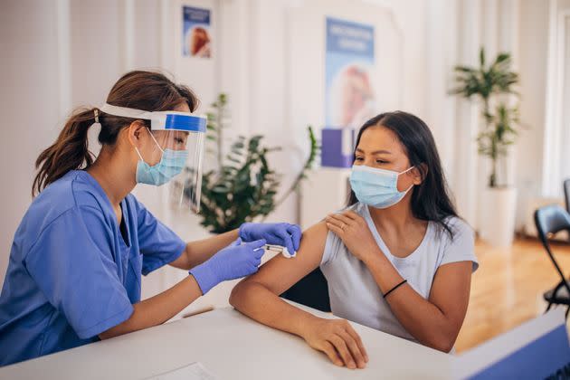 Diverse people at the vaccination center. woman receiving covid-19 vaccine. (Photo: South_agency via Getty Images)