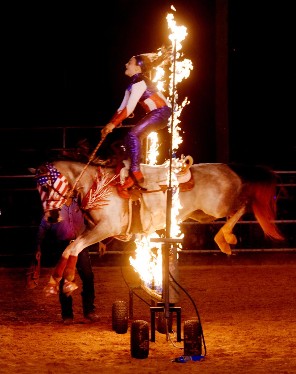 Trick rider Katie English performs on her horse during the 3rd annual Pete Colvin Memorial Rodeo in Minden in the Summer of 2023.