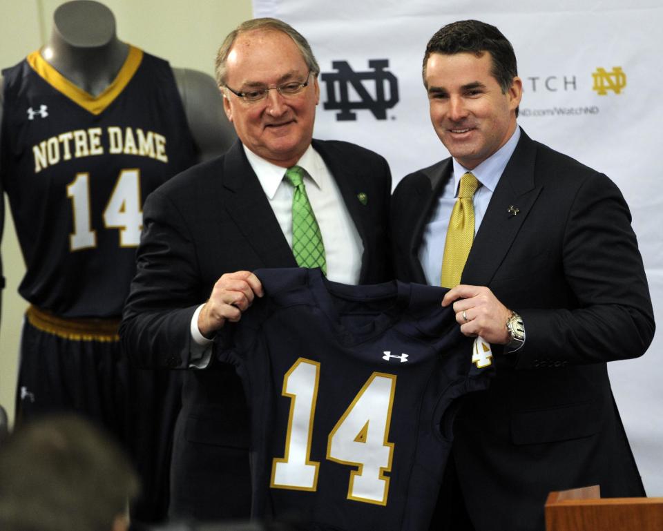 Jack Swarbrick, left, Notre Dame Vice President and Director of Athletics, left, and Kevin Plank, CEO and founder of Under Armour, hold up a jersey during a news conference Tuesday Jan. 21, 2014, in South Bend, Ind., announcing an agreement between Notre Dame and Under Armour that will outfit the university's athletic teams (AP Photo/Joe Raymond)