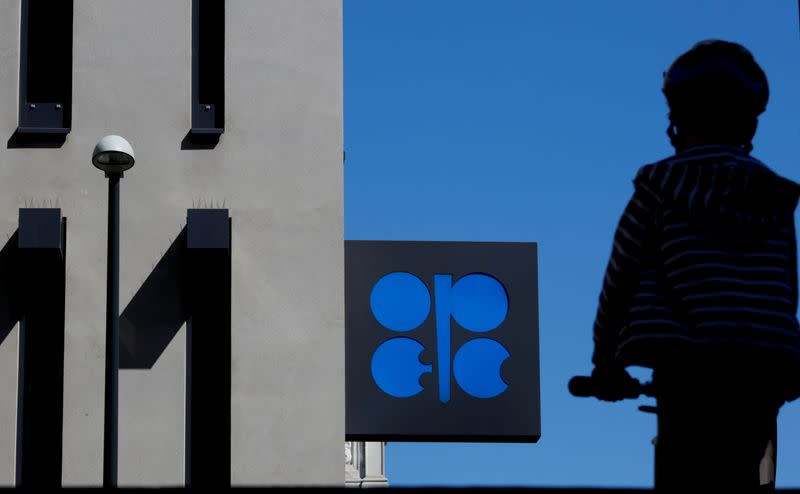 FILE PHOTO: A person passes the OPEC logo in front of its headquarters in Vienna