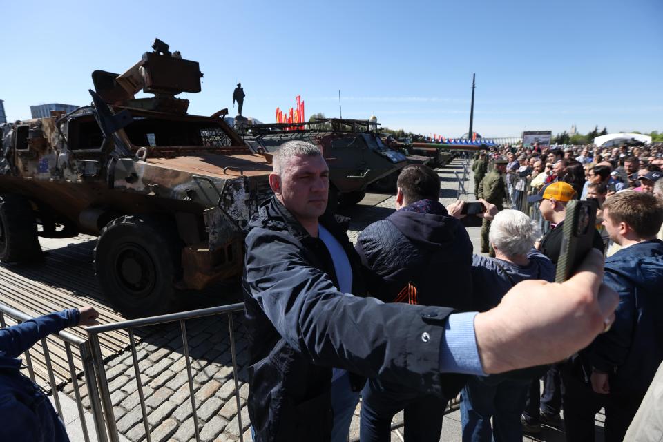 A visitor takes a selfie in front of an Australian Bushmaster PMV.