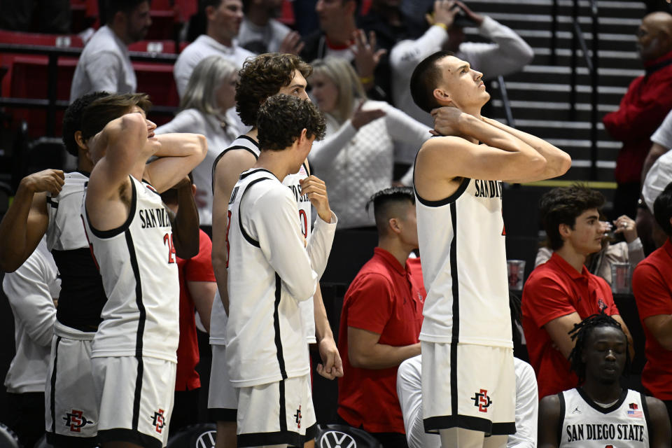 San Diego State players watch from the bench during the second half of the team's NCAA college basketball game against Boise State on Friday, March 8, 2024, in San Diego. (AP Photo/Denis Poroy)
