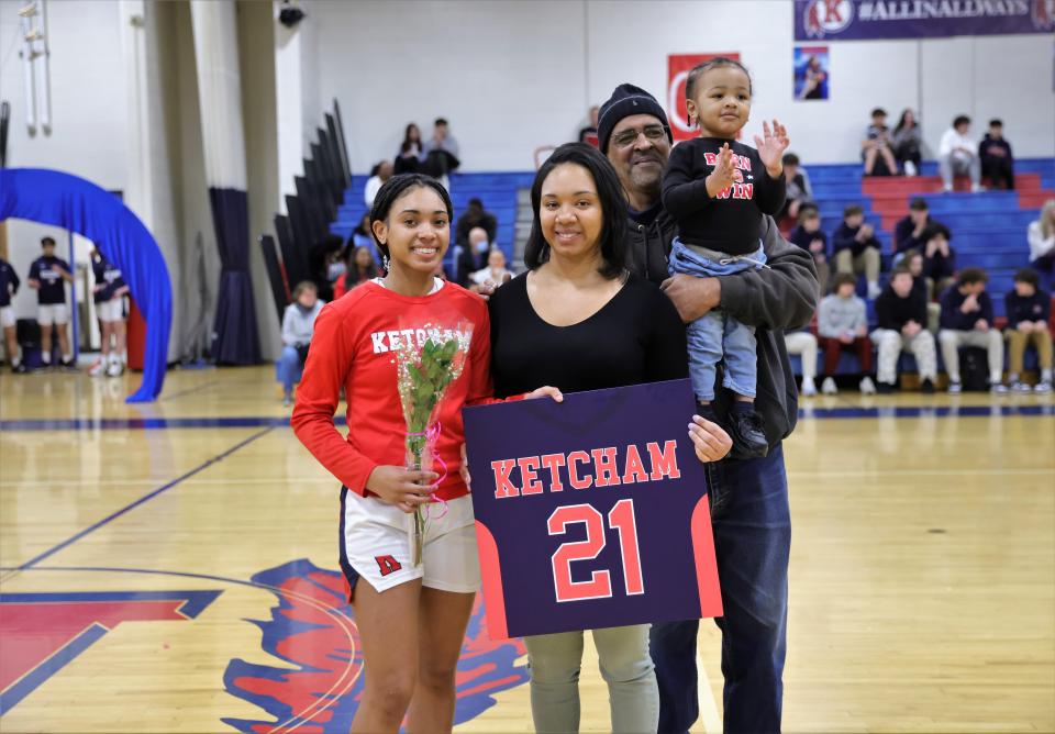 Ketcham's Tianna Adams, left, poses for a photo with her family during a pre-game ceremony as the girls basketball team celebrate its senior night.