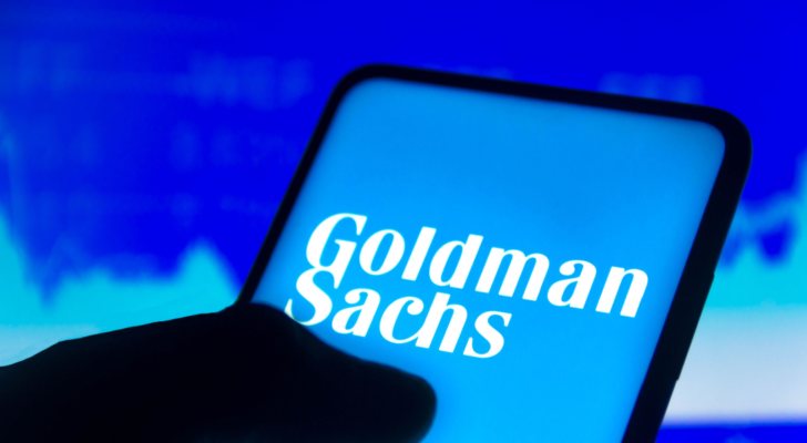 In this photo illustration the Goldman Sachs Group (GS) logo displayed on a smartphone screen and a stock market graph in the background