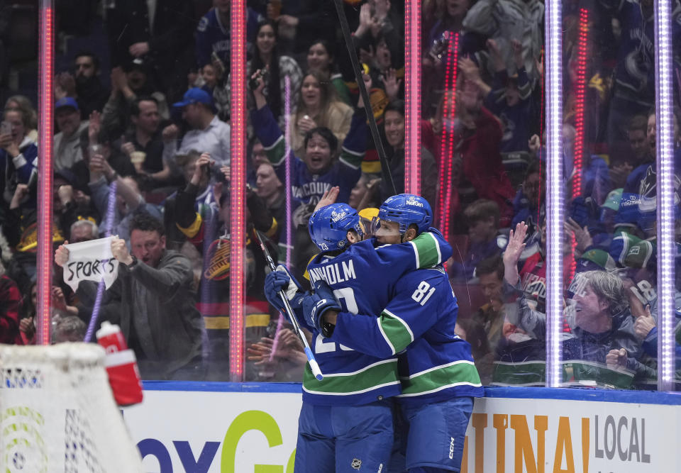 Vancouver Canucks' Dakota Joshua, right, and Elias Lindholm celebrate Joshua's goal against the Calgary Flames during the second period of an NHL hockey game Tuesday, April 16, 2024, in Vancouver, British Columbia. (Darryl Dyck/The Canadian Press via AP)