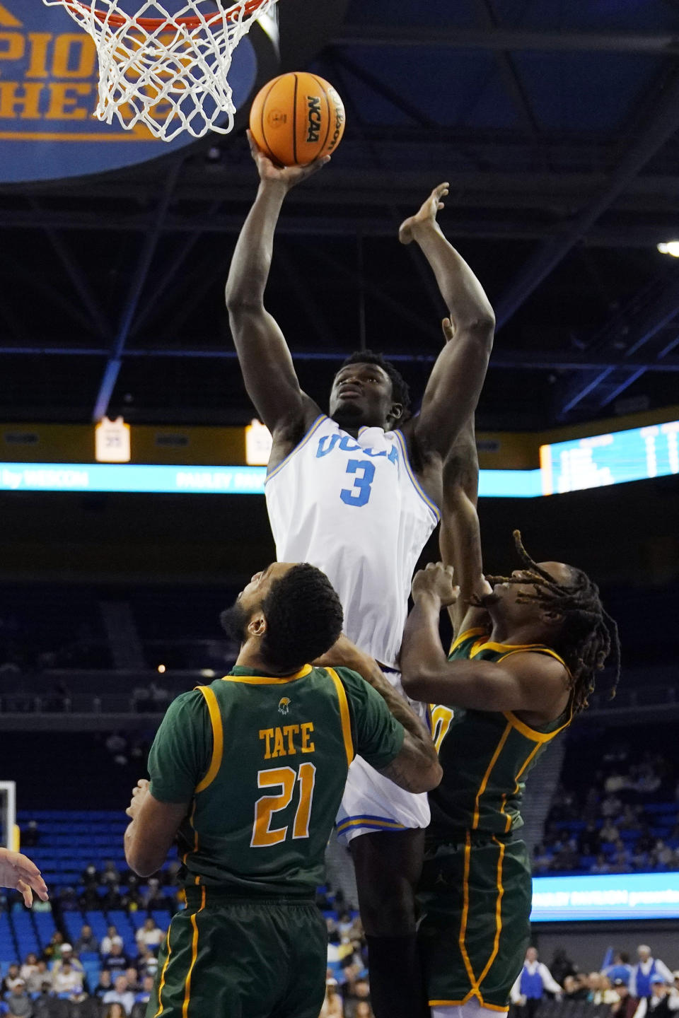 UCLA forward Adem Bona, center, shoots as Norfolk State forward Dana Tate Jr., left, and forward Kris Bankston defend during the first half of an NCAA college basketball game Monday, Nov. 14, 2022, in Los Angeles. (AP Photo/Mark J. Terrill)