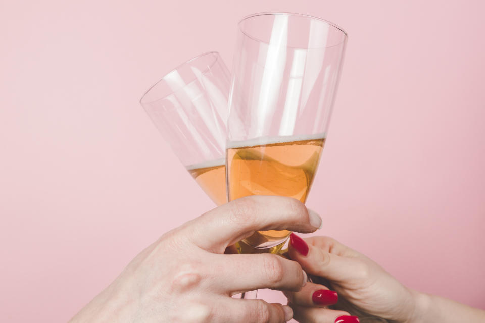 A close up of two women toasting with champagne glasses.