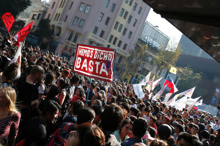 Demonstrators with a placard thats reads "We have said: Enough", take part in a protest demanding an end to profiteering in the education system in Santiago, Chile April 19, 2018. REUTERS/Rodrigo Garrido