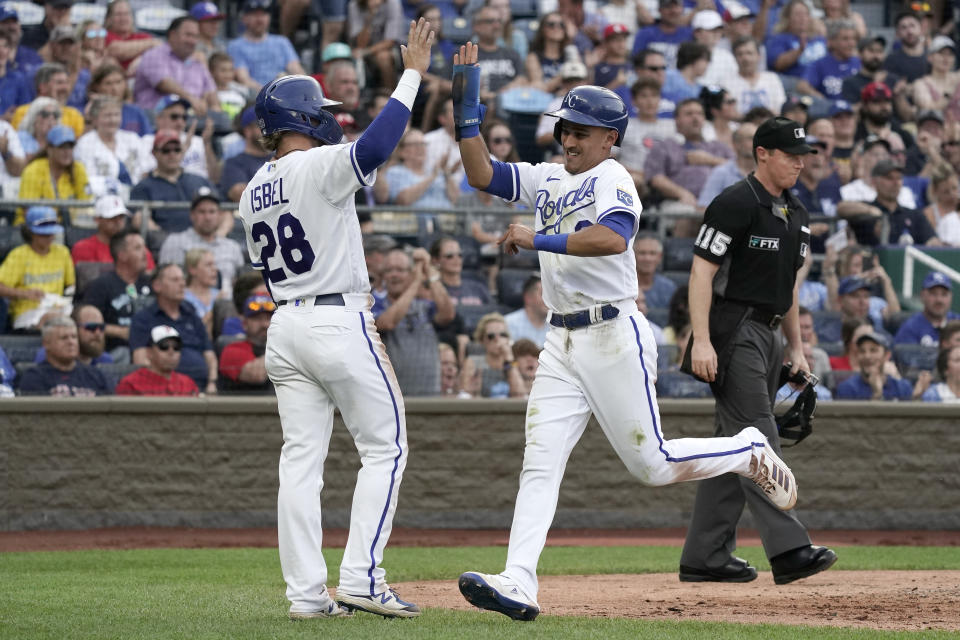 Kansas City Royals' Kyle Isbel (28) and Nicky Lopez celebrate after they scored on a single by Bobby Witt Jr. during the third inning of a baseball game against the Boston Red Sox Saturday, Aug. 6, 2022, in Kansas City, Mo. (AP Photo/Charlie Riedel)