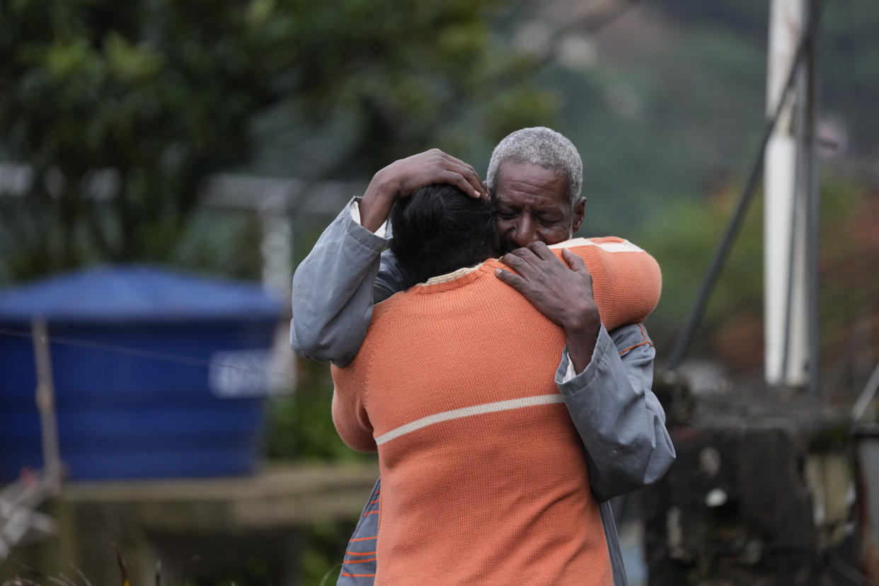 Residents embrace as they wait for a report for missing relatives in an area affected by landslides in Petropolis, Brazil, Wednesday, Feb. 16, 2022. Extremely heavy rains set off mudslides and floods in a mountainous region of Rio de Janeiro state, killing multiple people, authorities reported. (AP Photo/Silvia Izquierdo)