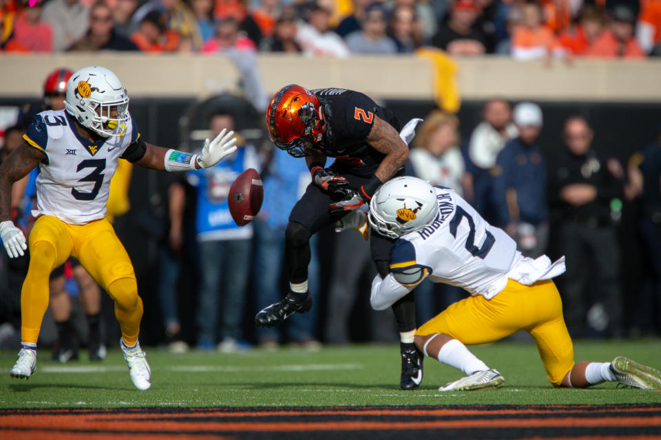 STILLWATER, OK - NOVEMBER 17: West Virginia Mountaineers safety Kenny Robinson Jr. (2) hits Oklahoma State Cowboys wide receiver Tylan Wallace (2) causing a fumble during the Big 12 college football game on November 17, 2018 at Boone Pickens Stadium in Stillwater, Oklahoma. (Photo by William Purnell/Icon Sportswire via Getty Images)