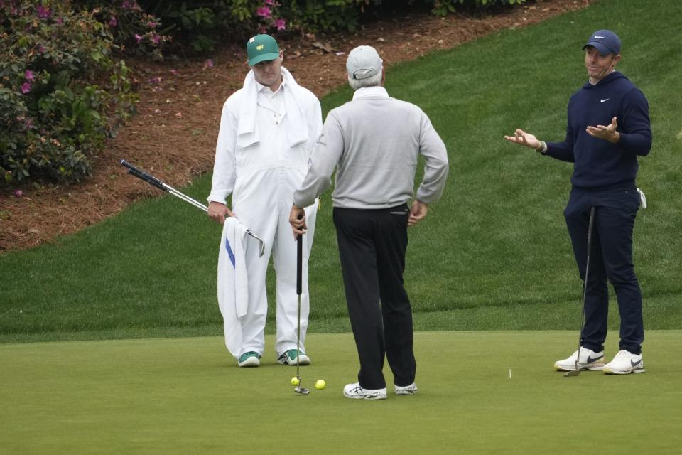 Rory McIlroy (right) gestures while talking to Fred Couples on Monday.