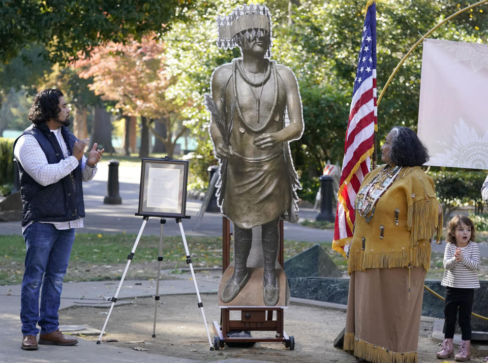Jesse Tarango, left, chairman of Wilton Rancheria, and his mother Mary Tarango, second from right, look at an enlarged photo of a statue of the late William Franklin Sr. during a groundbreaking ceremony for a Native American monument at Capitol Park in Sacramento, Calif., Monday, Nov. 14, 2022. The actual statue of Franklin will replace a statue of Fr. Junipero Serra, whose statue was torn down by protesters in 2020. The new statue is expected to be placed in the park in early 2023. (AP Photo/Photo/Rich Pedroncelli)