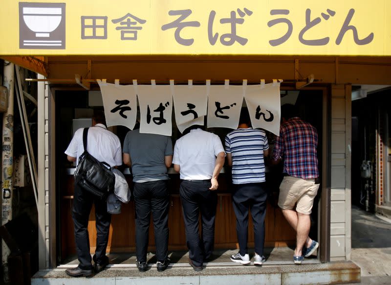 FILE PHOTO: People eat Japanese soba and udon noodles at a stand-up noodle shop called "Tachigui Soba" in Tokyo