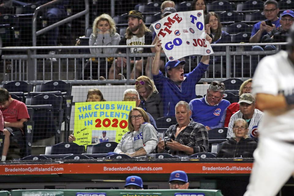 A Chicago Cubs fan holds a sign as Cubs manager Joe Maddon, bottom right, stands in the dugout during the ninth inning of the team's baseball game against the Pittsburgh Pirates in Pittsburgh, Thursday, Sept. 26, 2019. The Pirates won 9-5. (AP Photo/Gene J. Puskar)