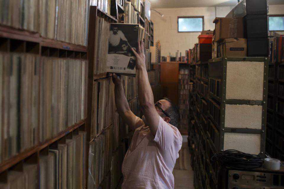 Carlos Savalla vuelve a colocar nos discos en un estante de su estudio donde mantiene su colección de música, en Río de Janeiro, Brasil, el viernes 19 de abril de 2024. Savalla, un productor musical de 66 años de Río, posee más de 60.000 discos de vinilo. (Foto AP/Bruna Prado)