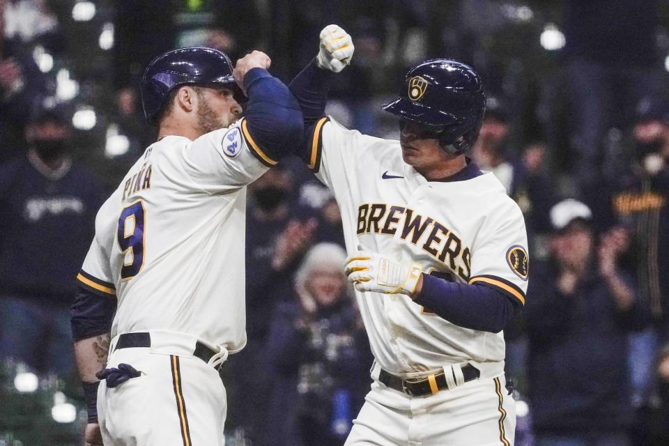 Milwaukee Brewers' Luis Urias is congratulated by Manny Pina (9) after hitting a two-run home run during the second inning of a baseball game against the Chicago Cubs Tuesday, April 13, 2021, in Milwaukee. (AP Photo/Morry Gash)