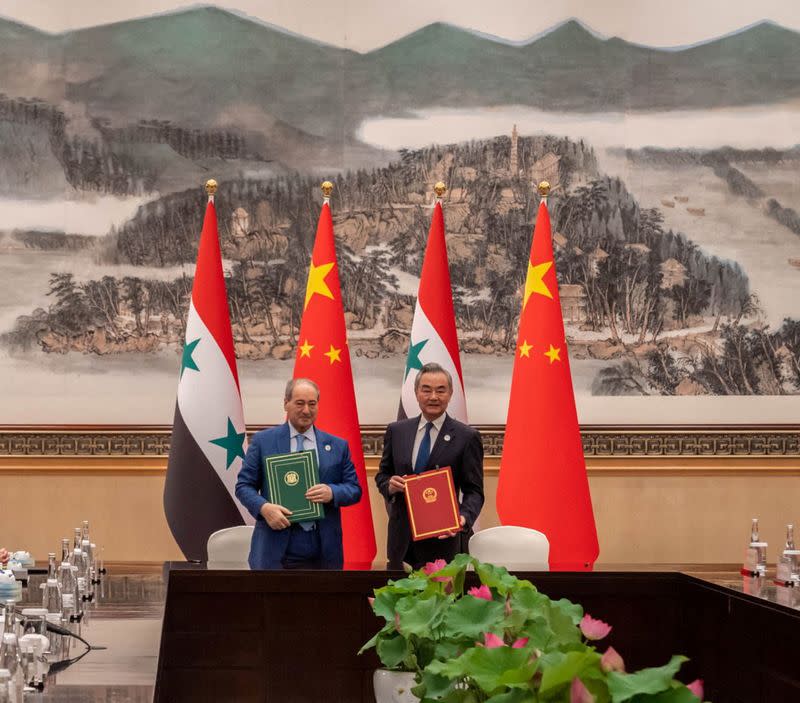 Syrian Foreign Minister Faisal Mekdad and Chinese Foreign Minister Wang Yi pose for a picture, in eastern Hangzhou city